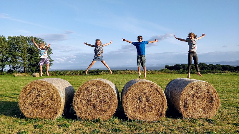 Kids jumping on hay bales